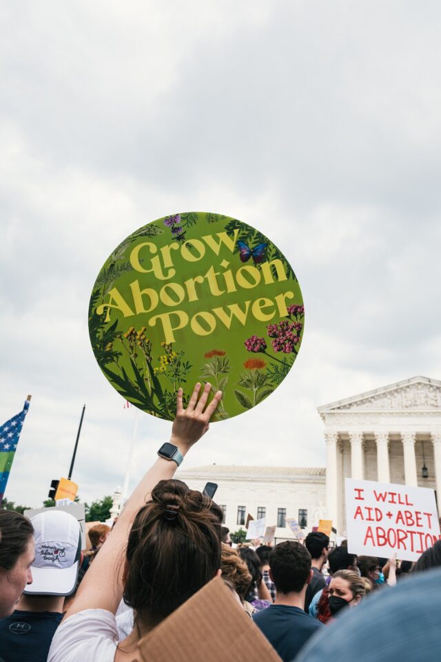 Woman holding a sign at an abortion rights protest saying “Grow Abortion Power” 