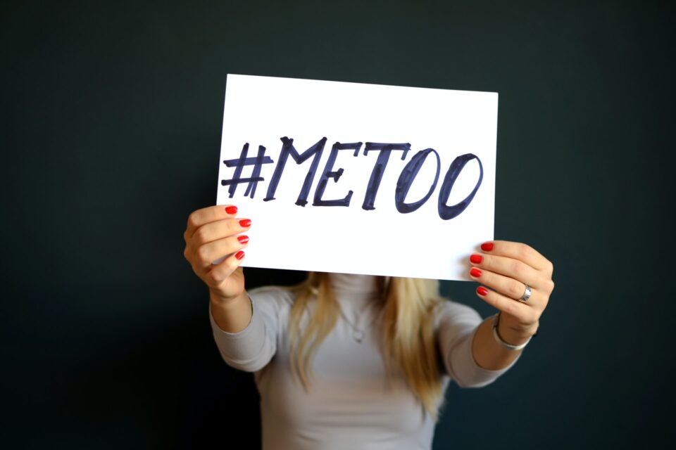 Woman holding up a sign that says #METOO