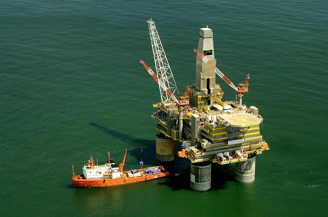 A photo of a generic offshore oil rig, with a boat next to it.